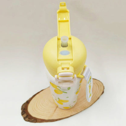A yellow and white water bottle with a lemon pattern, shown on a wooden slice coaster against a light background.